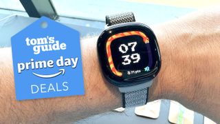 Fitbit Ave LTE in a user&#039;s wrist next to a Prime Day deals badge