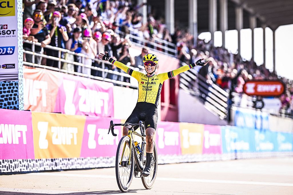 Pauline Ferrand-Prevot cruza la meta para ganar la París-Roubaix 2025, con gradas llenas de aficionados detrás de ella