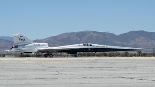a long, slender aircraft drives across a runway