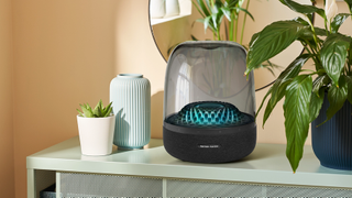 Harman Kardon Aura Studio 4 on a side table with a plant