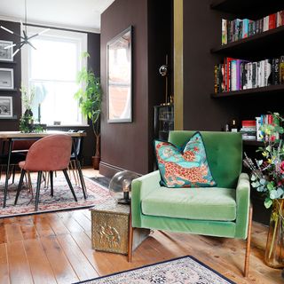 a green velvet armchair in an open plan living/dining room