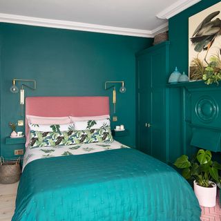colour drenched teal bedroom with fireplace and metallic wall lights