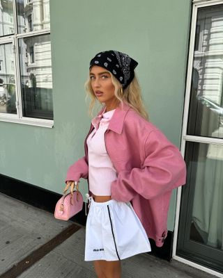 Emili Sindlev wearing a pink outfit with a bandana headscarf.