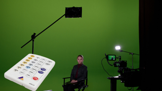 The new Astera White Remote with a woman sitting under a light in front of a green screen. 