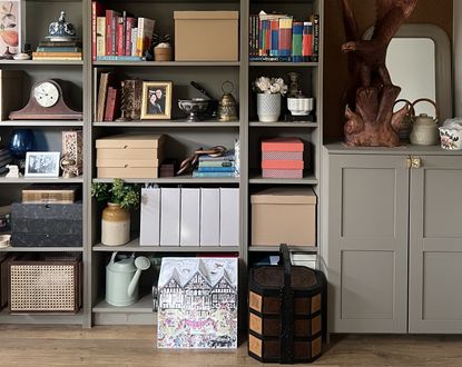 A living room with wooden floors and built-in shelving painted in a beige color