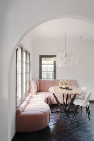 A breakfast nook with a pink sofa