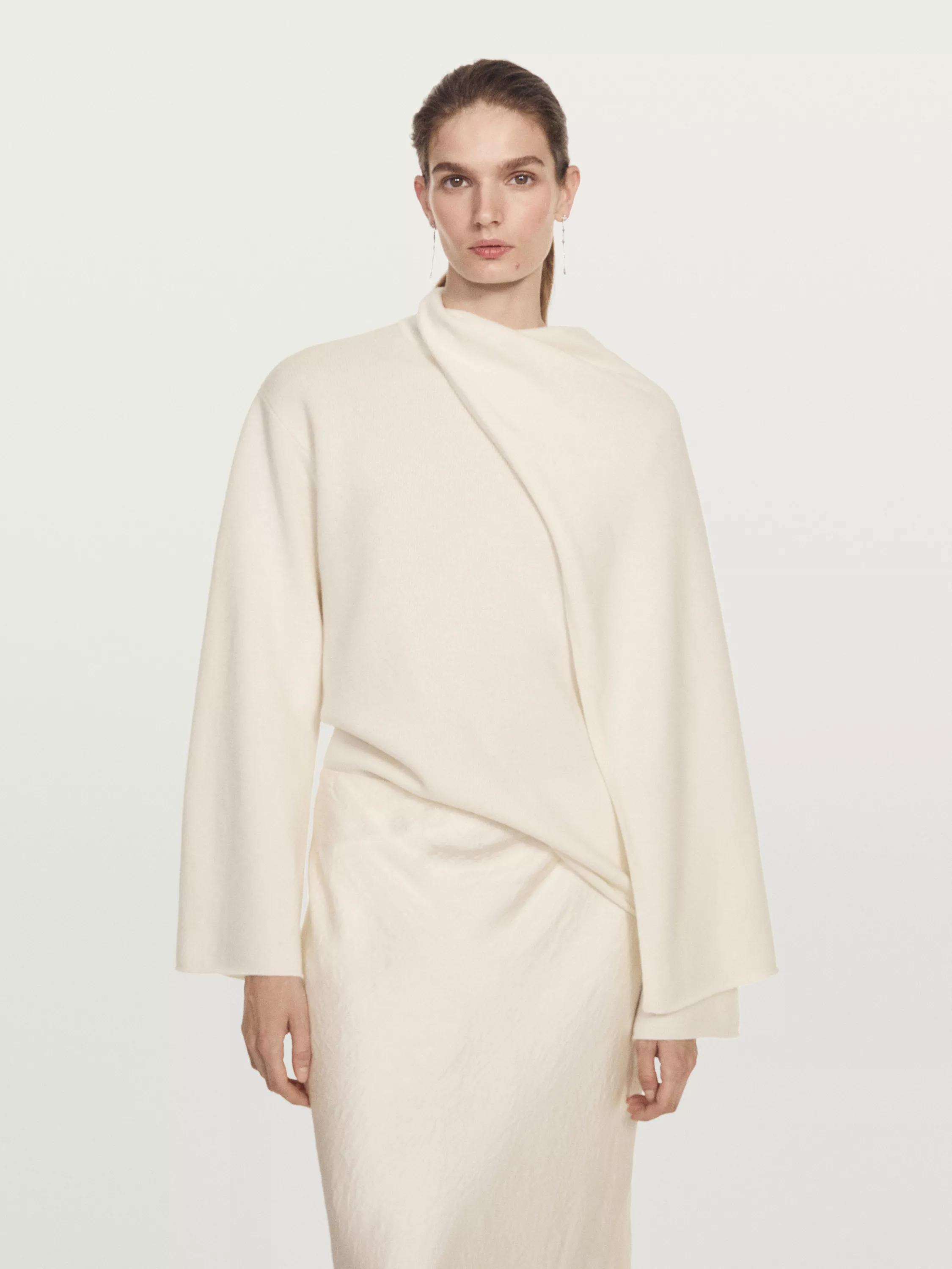 Woman wears cream scarf jumper and cream satin skit