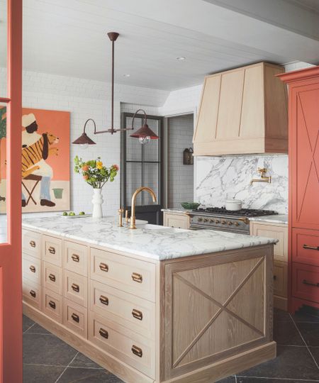 A wooden kitchen with a marble countertop
