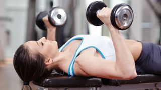 woman doing dumbbell chest press exercise