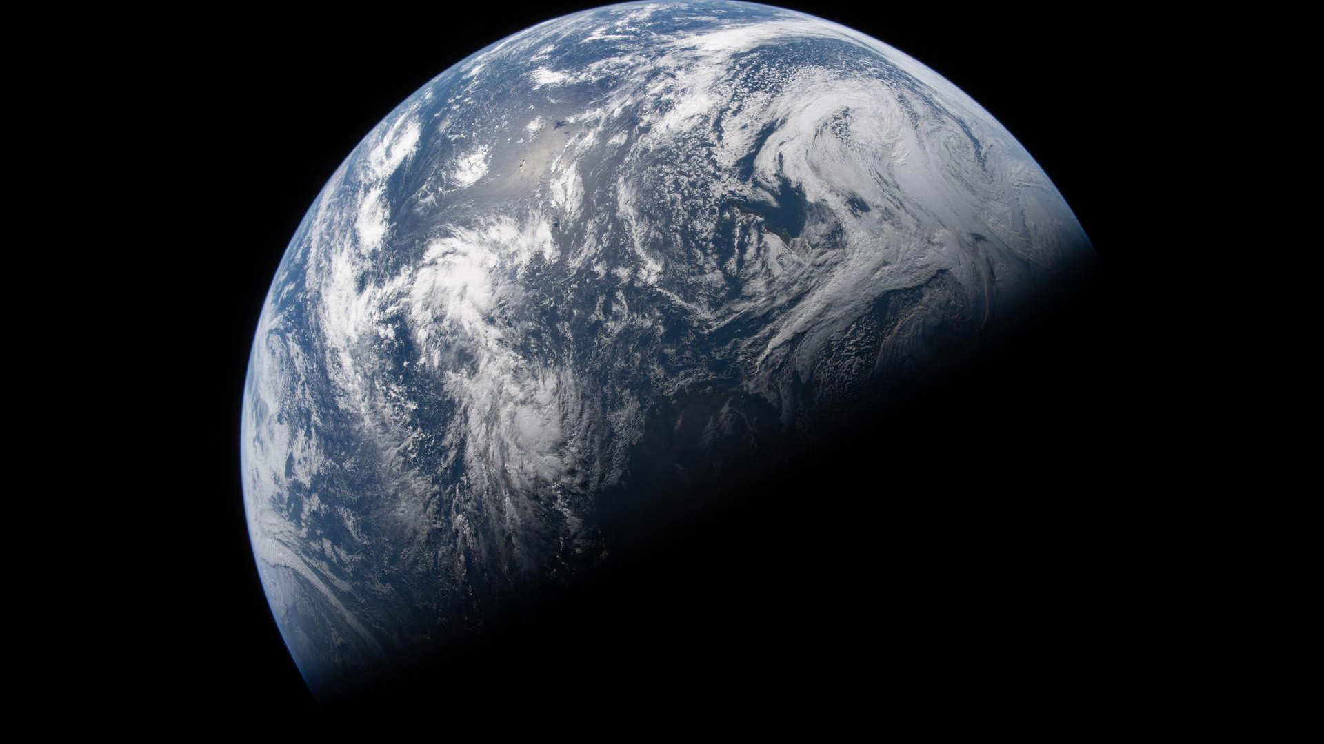 The planet Earth with its bottom half covered in shadow.