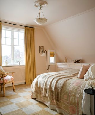 pale pink bedroom with yellow check rug and spring accessories