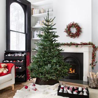 An artificial Christmas tree in a living room with a Christmas decoration storage