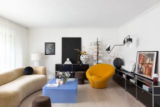 a contemporary living room with a yellow chair and blue coffee table