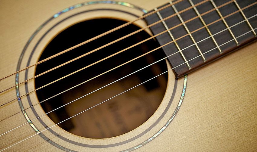 The outer abalone soundhole ring, along with 12th fret and headstock inlays, underlines the subtle class of this guitar