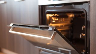An oven preheating with its door open