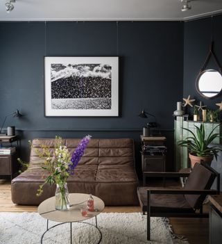 black living room with brown leather sofa and black lamps