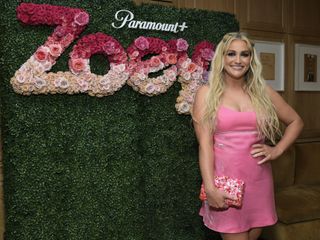 Jamie Lynn Spears attends the "Zoey 102" Cocktail Party in a pink minidress and sparkly pink clutch bag.