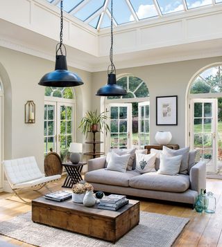 Wood coffee table in front of grey sofa in an open plan conservatory