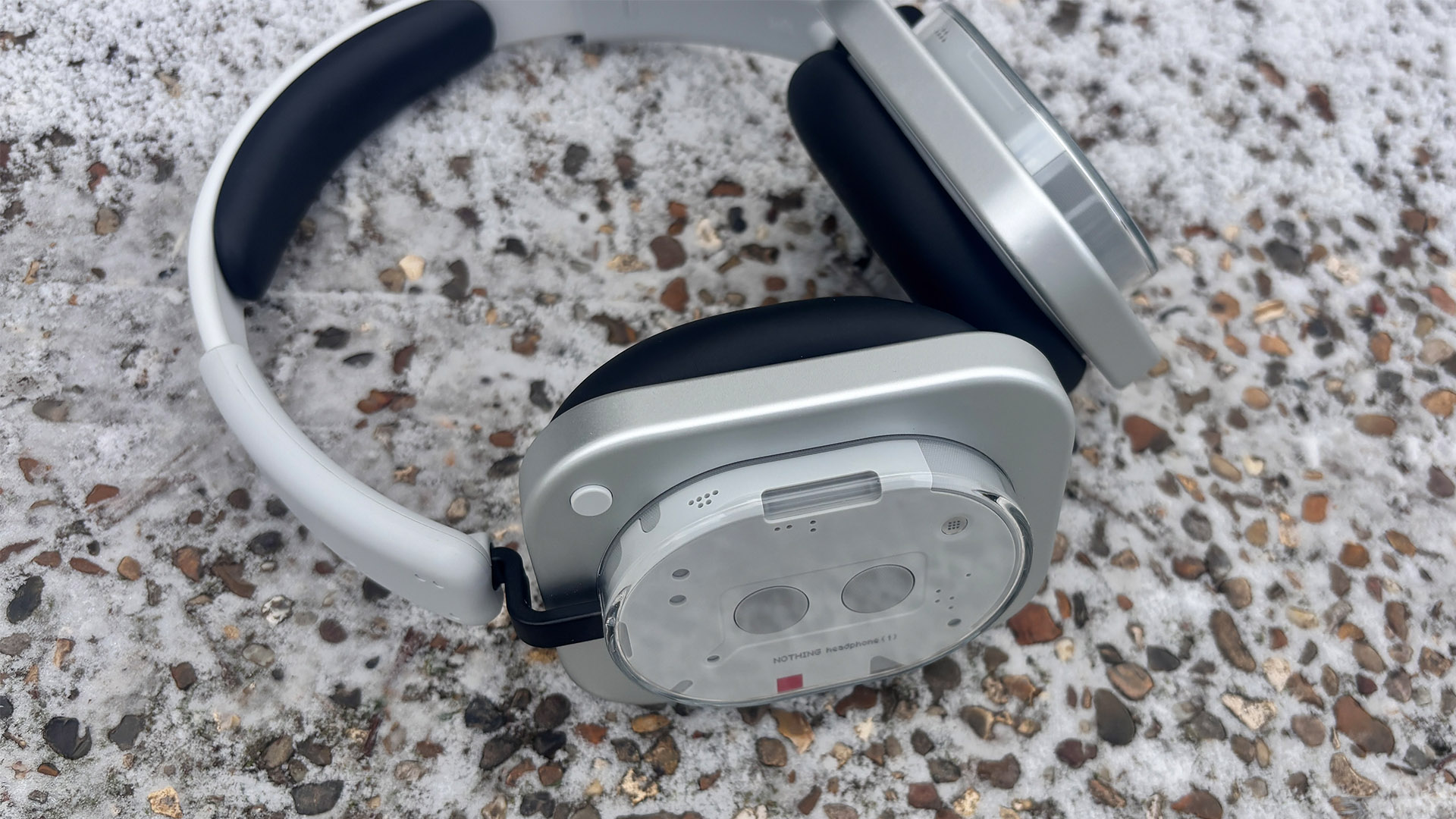Nothing Headphone (1) wireless headphones lying on concrete/gravel