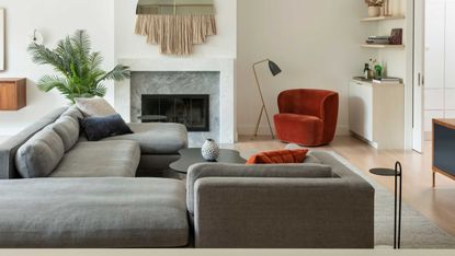 a living room with a grey sofa and red chair