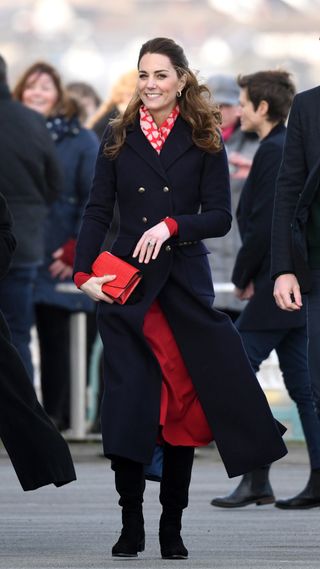Kate Middleton in a black tailored coat and red dress