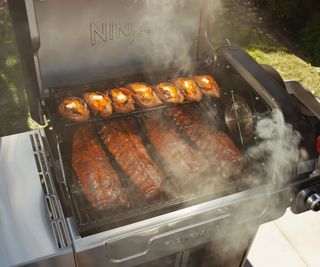 A Ninja FlexFlame grill cooking ribs and sweet potatoes