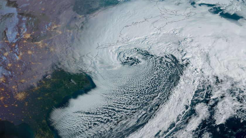 A satellite view of a large white spiral over land and sea representing the northeast U.S.