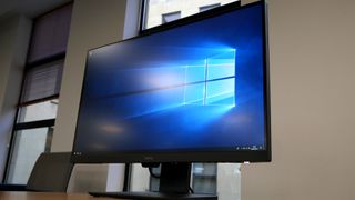 BenQ PD2700U in a home office showing the Windows background