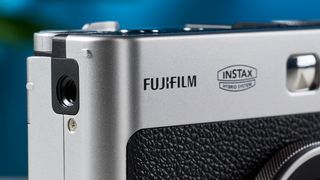 A close-up of the Fujifilm logo on an instant camera