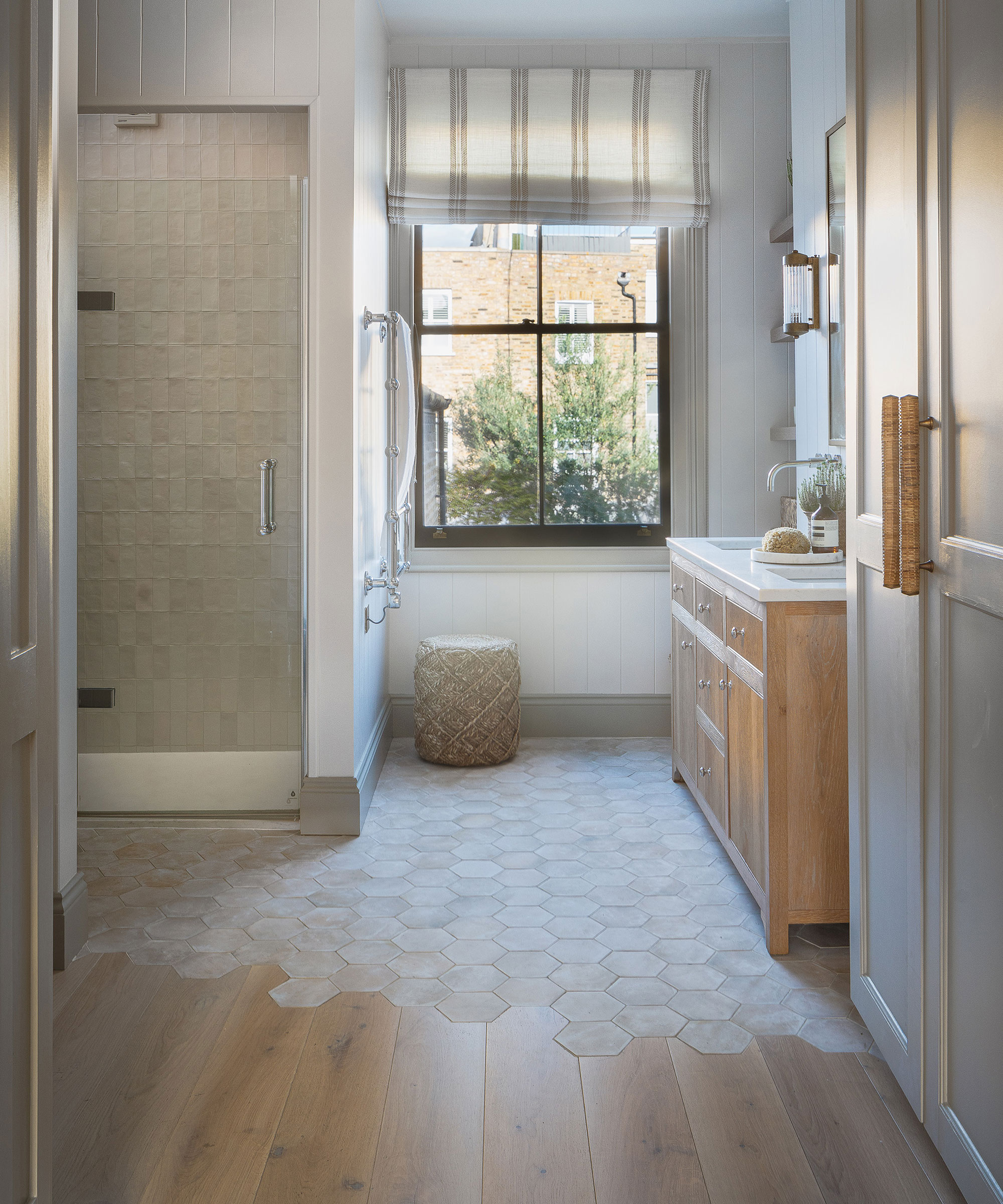 modern shower room with half wooden flooring and half hexagonal floor tiles with wooden vanity unit