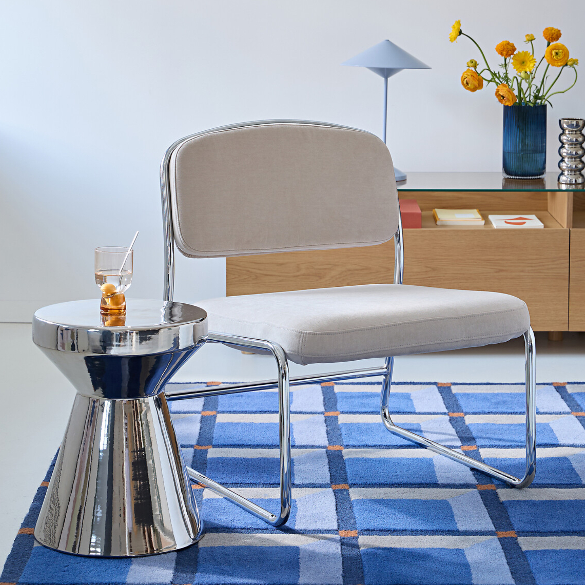 blue rug with chrome side table and cream chair