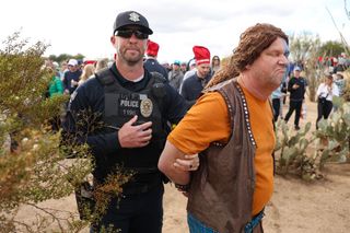 A fan gets escorted by a police officer at the WM Phoenix Open