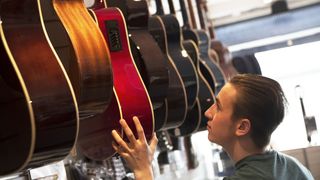 Mn in a guitar shopping perusing a range of acoustic guitars