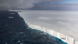 aerial view of a colossal iceberg stretching to the horizon.