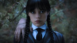 Jenna Ortega in Wednesday with Thing on her shoulder.