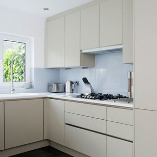kitchen area with cupboard and white wall