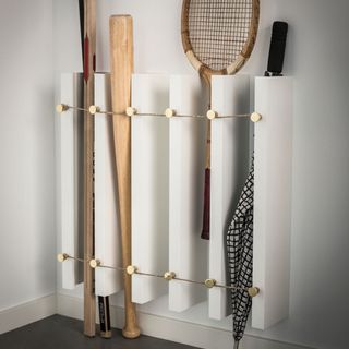 white wall with vertical storage and baseball racket