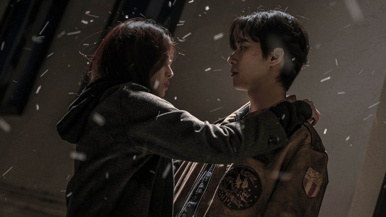 Han So-hee (as Yoon Chae-ok) rests her hand on Park Seo-jun&#039;s (as Jang Ho-jae) shoulder as it snows, in Gyeongseong Creature S2.