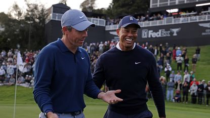 Rory McIlroy (left) and Tiger Woods share a joke on the 18th green during the first round of the The Genesis Invitational at Riviera Country Club