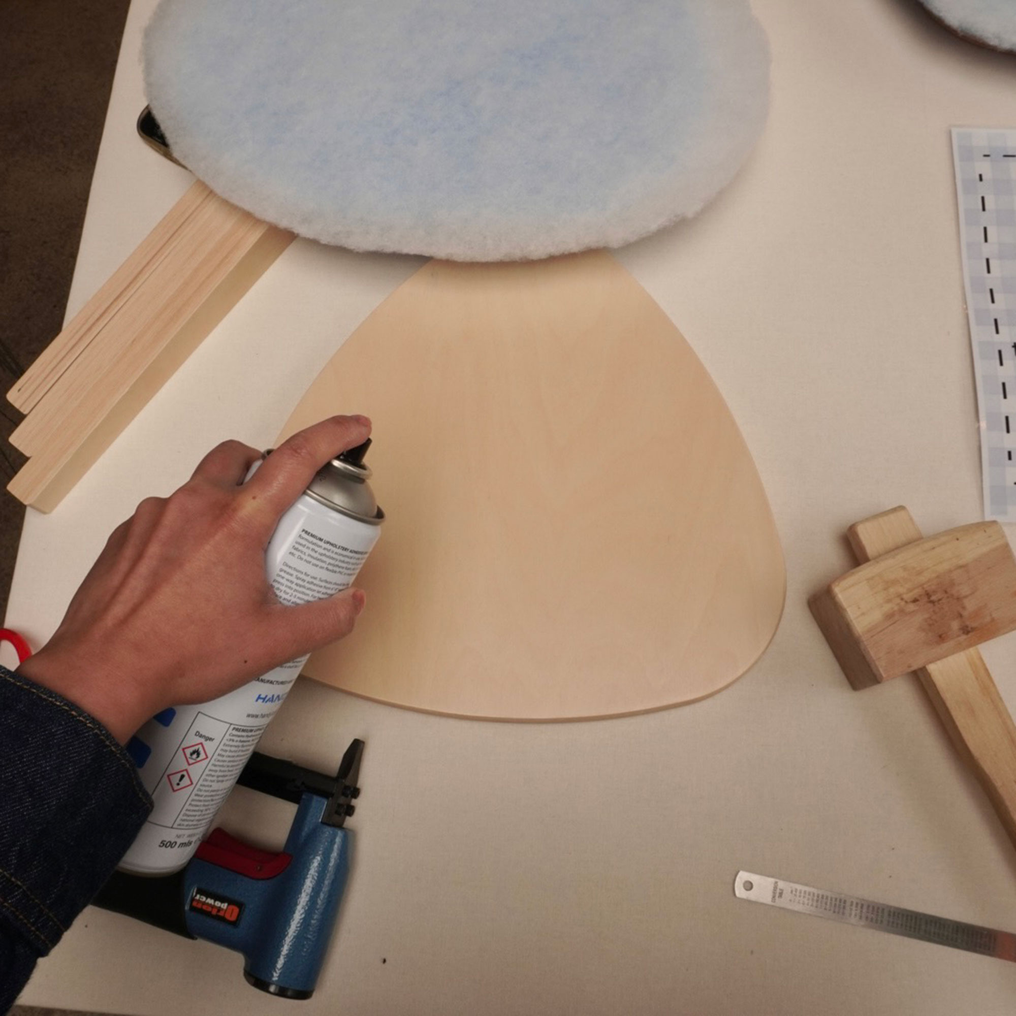 Flat lay of tools for upholstering wooden stool