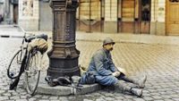 Lunch of a French soldier in front of a damaged library. 1st April 1917. He is sitting at a lamp post in a square in Reims with his bicycle next to him. Western Front. World War I. Autochrome Lumi&egrave;re. Photo: Paul Castelnau (1880-1944). France. &nbsp; (Photo by Galerie Bilderwelt/Getty Images)