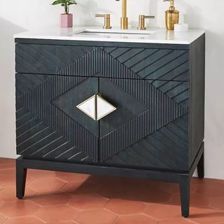 Handcarved Samuel Vanity with a gold faucet on top of terracotta hexagon floor tiles