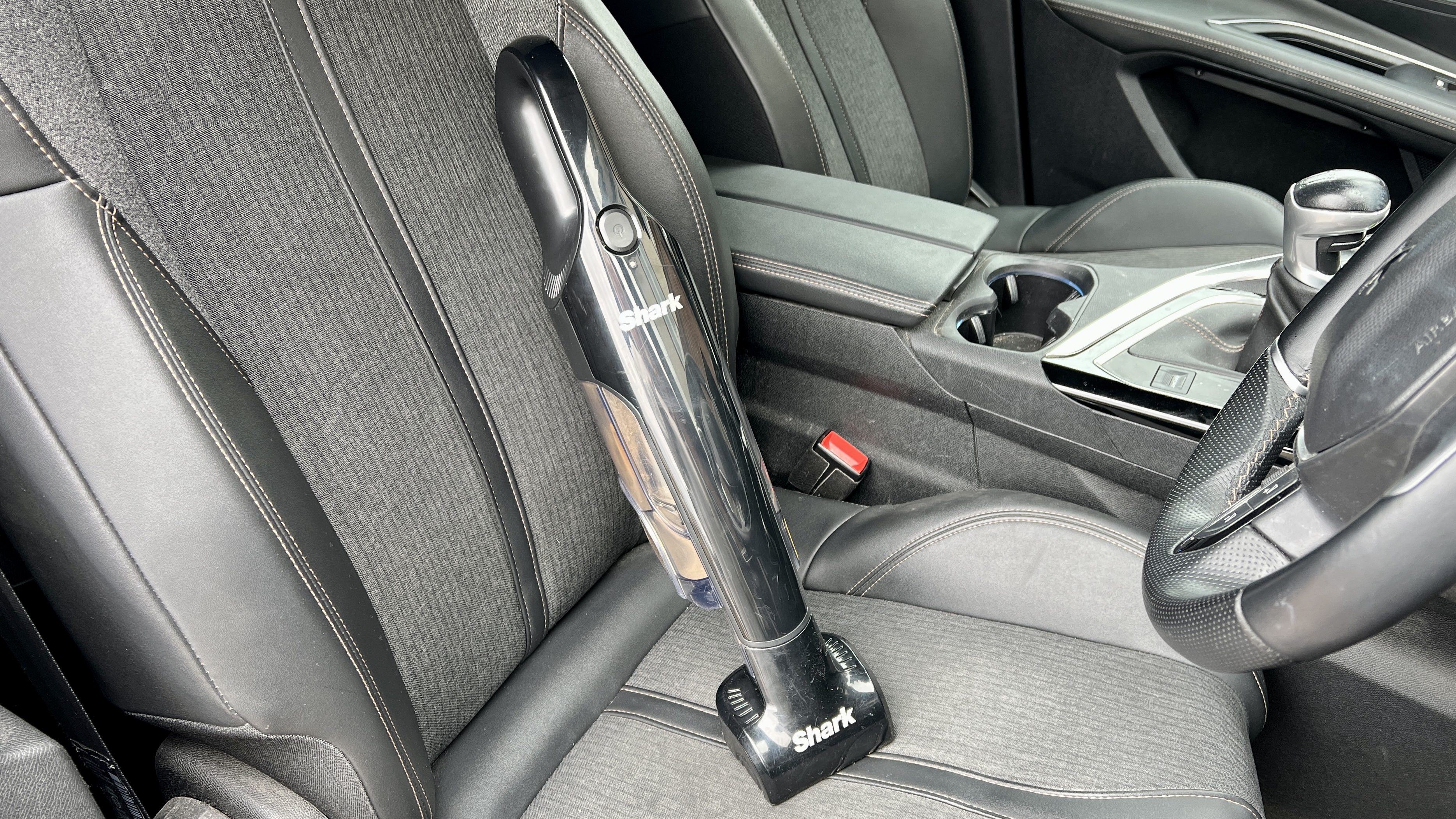 The Shark UltraCyclone Pet Pro Plus handheld vacuum resting on reviewer's car seat