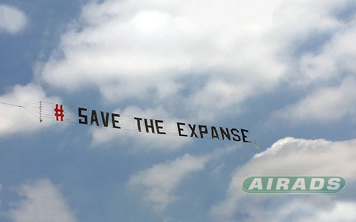 A banner goes across the sky reading &quot;# SAVE THE EXPANSE&quot;