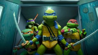 (L to R) Michelangelo, Donatello, Leonardo and Raphael standing with their weapons out in a doorway in Teenage Mutant Ninja Turtles: Mutant Mayhem
