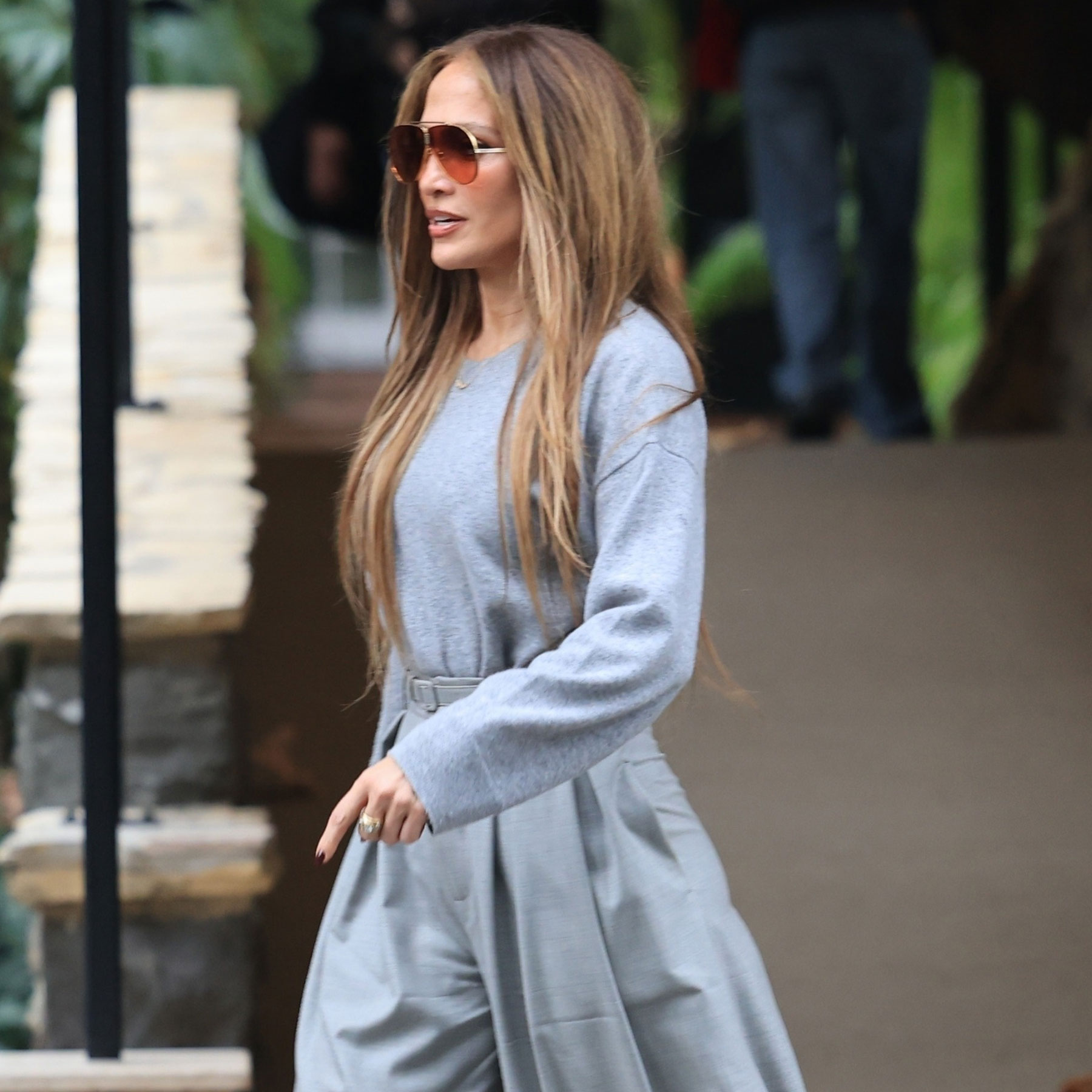 Jennifer Lopez wears gray wide-leg pants with platform heels