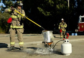 Alameda County firefighter Bob Perez lowers a 13-pound turkey into a pot of boiling oil during a safety demonstration Nov. 26, 2003 in San Leandro, California. The demonstration was meant to reduce the number of home fires and fatalities linked to deep-frying turkeys on the stovetop.