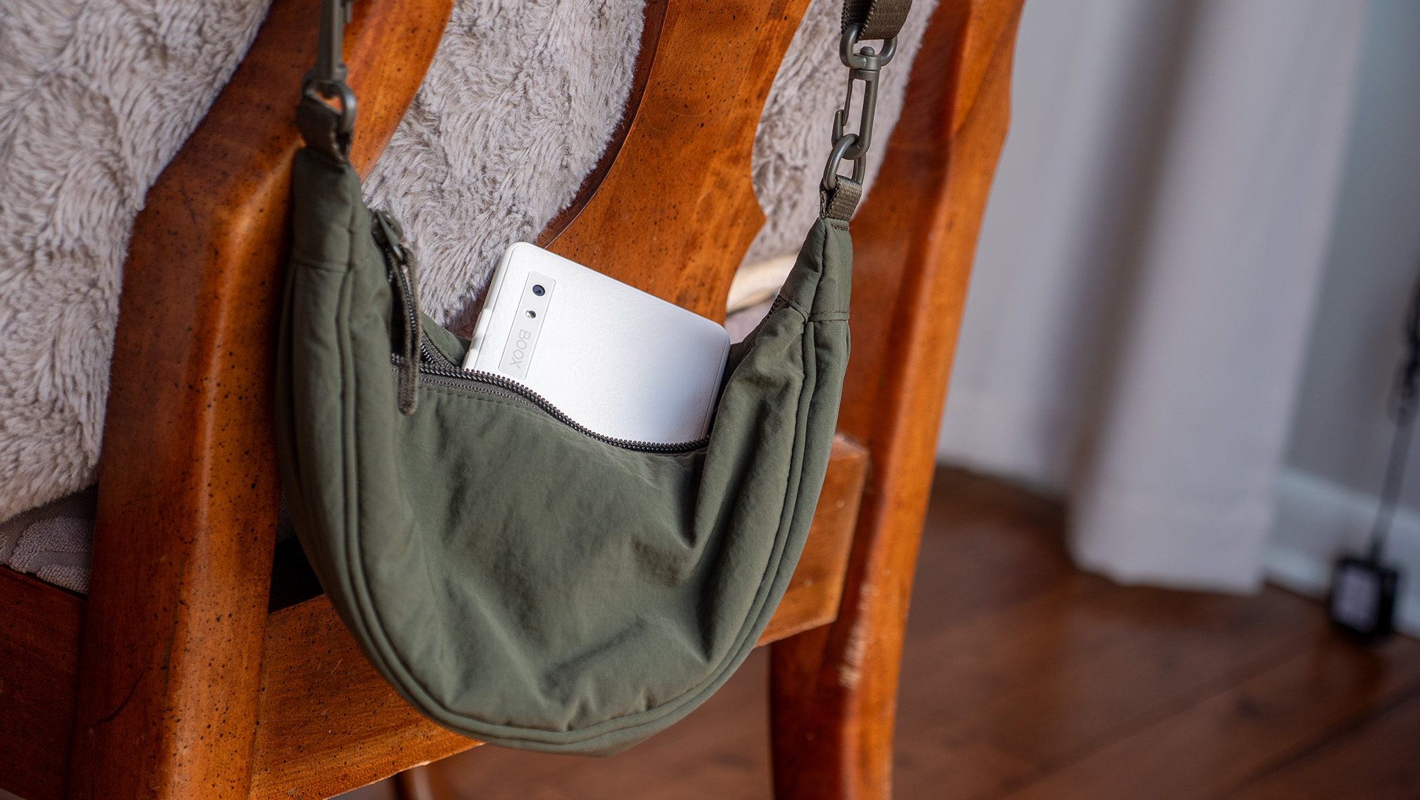 A white Onyx Boox Palma 2 in a small green purse