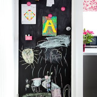 blackboard with pink flower and white wall
