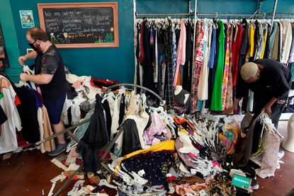 People clean up damage done by looters in a Los Angeles shop.